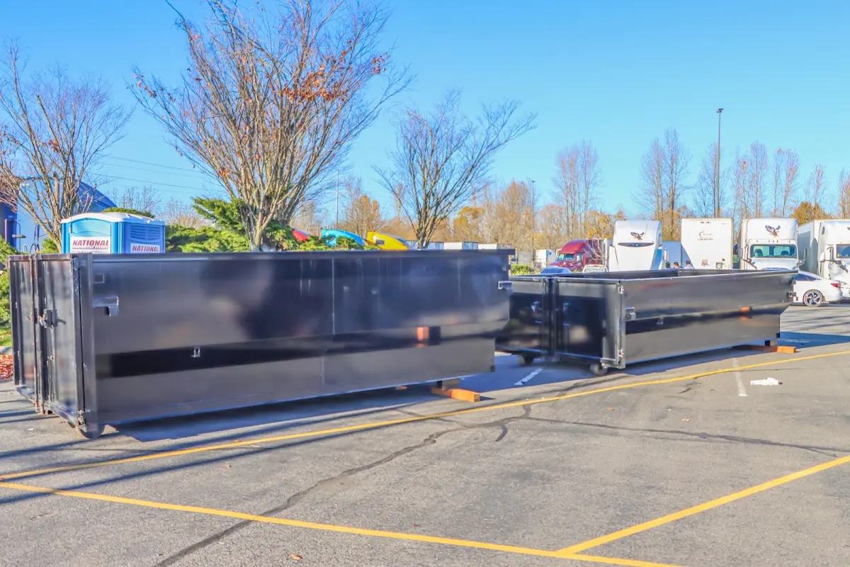 Professional dumpster rental service with roll-off container on residential driveway in Belding